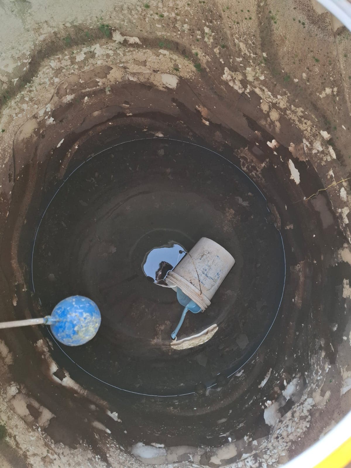 Round underground sump with sludge and debris before cleaning