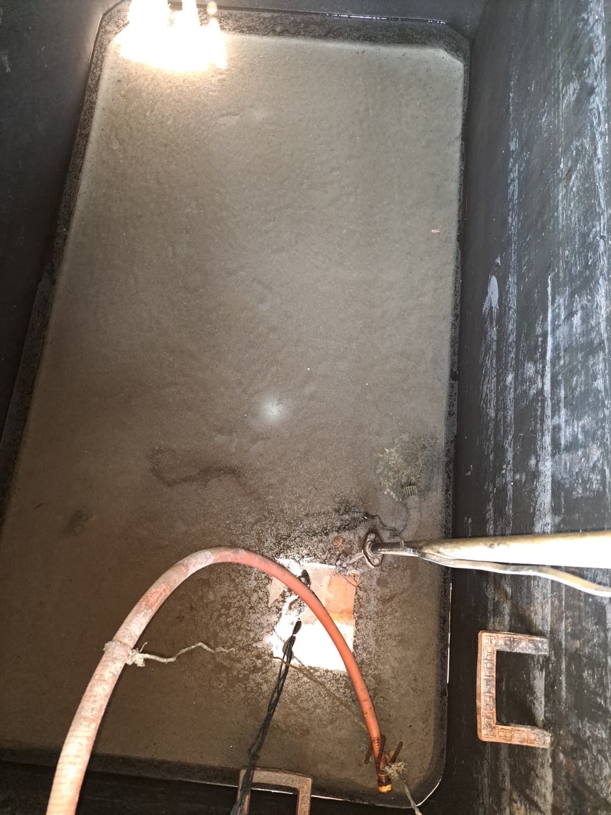Inside of a dirty sump with algae on the walls